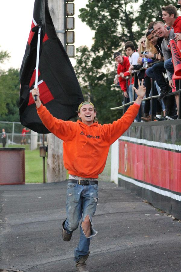 Senior Elijah McArthur runs  in front of the student section during a football game 