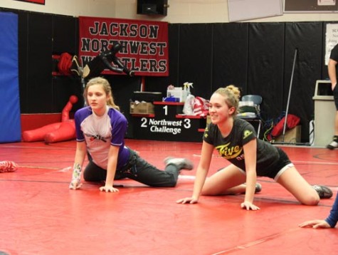 Freshman Sydney Boulter and junior Faith Boutler, sisters, stretch with the wrestling team before practice.