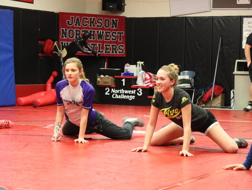 Freshman Sydney Boulter and junior Faith Boutler, sisters, stretch with the wrestling team before practice. 