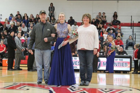 Senior Madison Perrin walking with her parents as a member of Snowfest Court 2016.