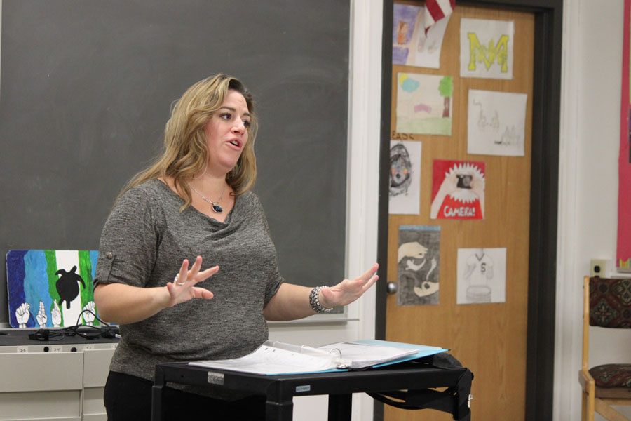 Maxwell signs “rain” to her ASL 3B students. Sign language heavily depends on facials to relay the emotion of a message.