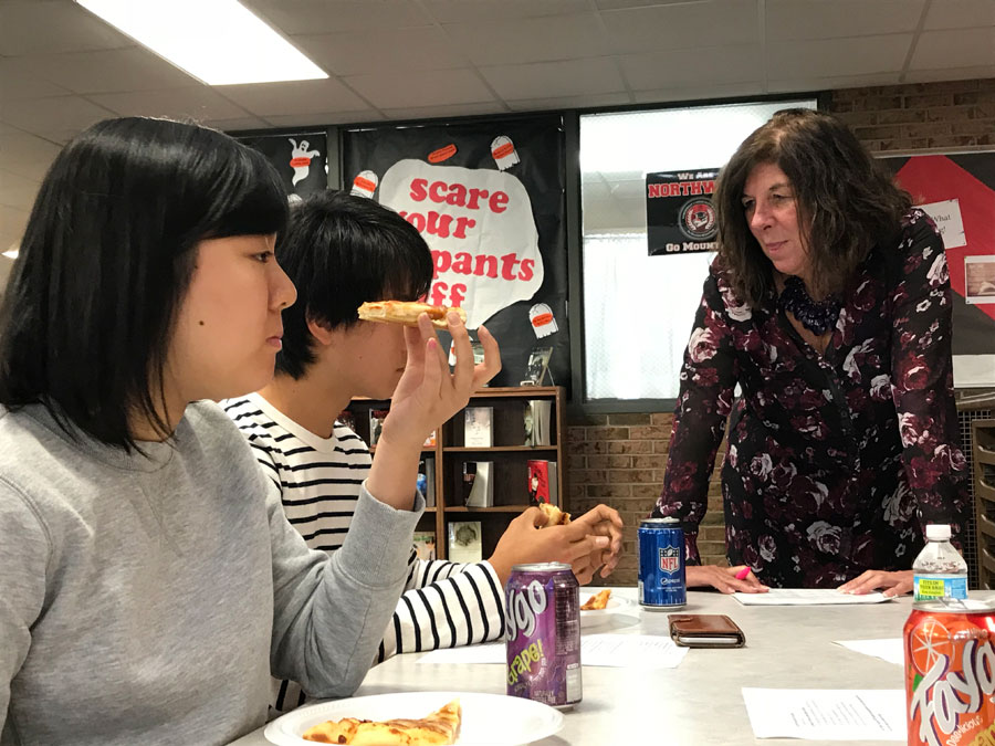 Senior Shiori Ogata eats Marino’s pizza with her fellow new students and Ms. Judy Scott during the new student lunch in the library on Oct. 12. Ogata explains how pizza is different in her home country of Japan.