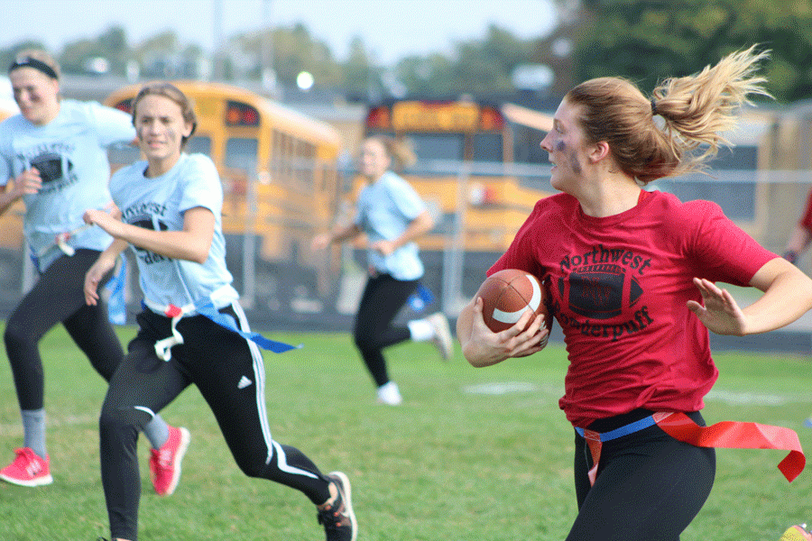 Senior Olivia Piepkow runs the ball to the end zone, scoring one of her many touchdowns during the powder-puff championship game. The senior class prevailed by defeating the juniors.