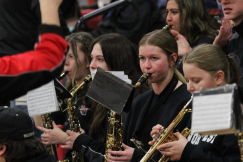 Seniors Lioba Werner, Chloe Laird, Khrystine Weesner, and Kennedy Maynard (right to left) playing in the pep band at  Snowfest games.  