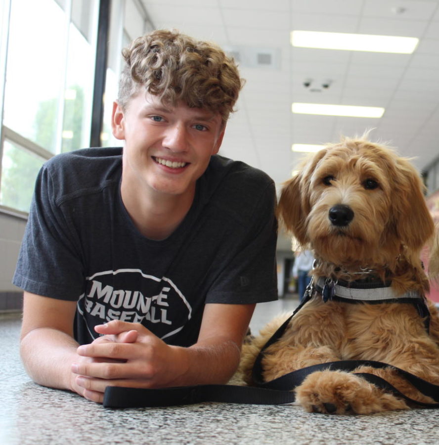 Senior Kaleb Kittinger-munro posing for an image with his favorite therapy dog, Maxie.
