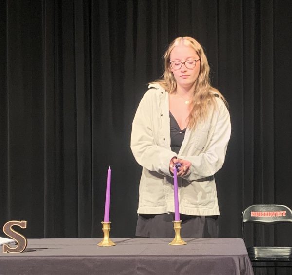 National Honors Society Journalist, Emma Flynn lighting her candle.