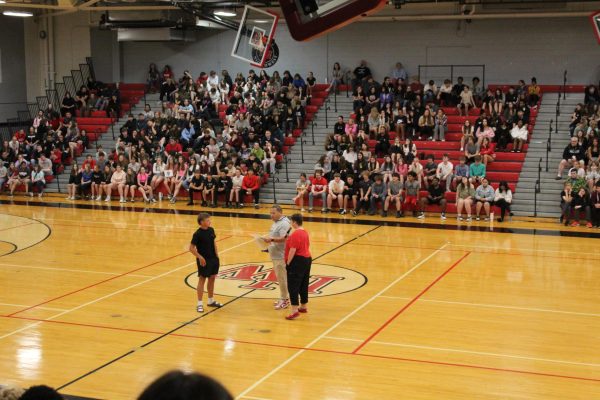 Wide view of the students and staff in the gym.