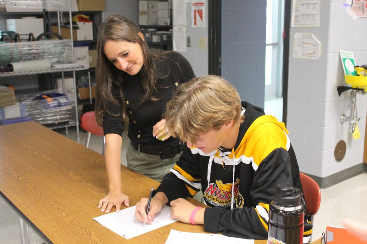 Whitely helping senior Will Atwood with his AP Physics work.