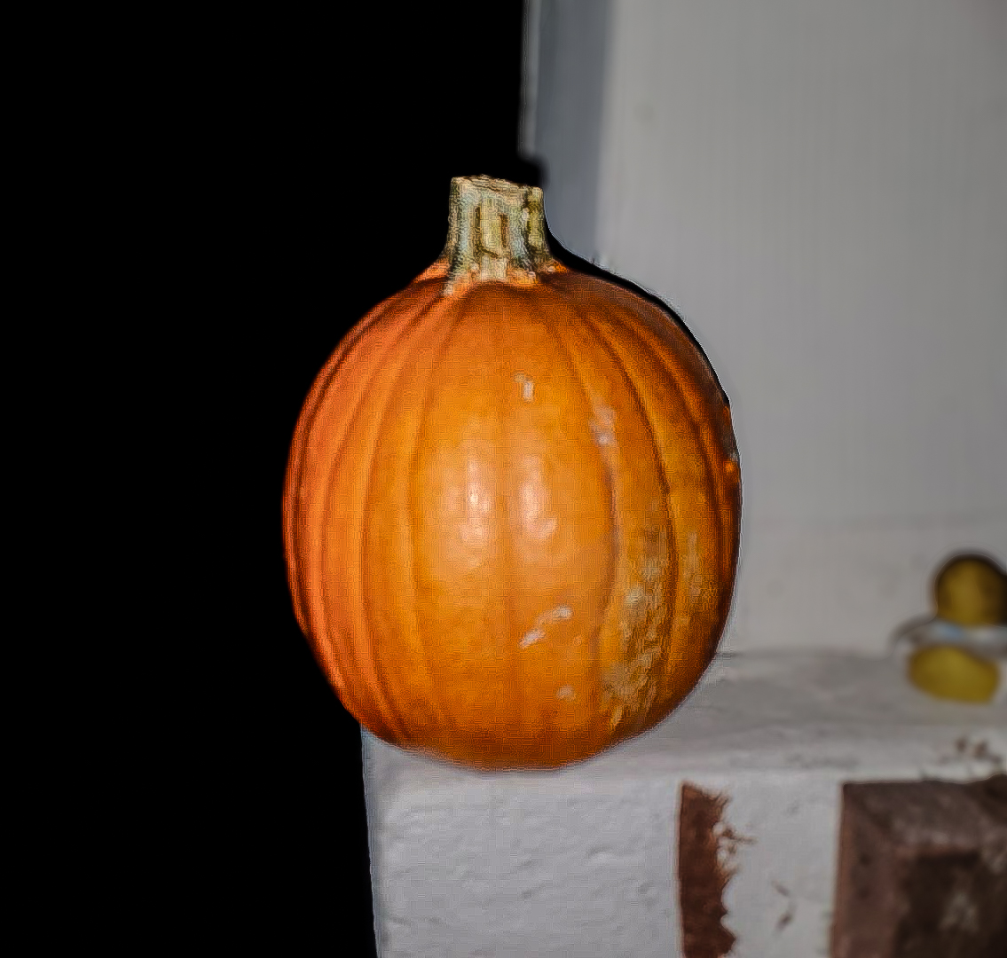 A pumpkin sitting on the edge of a porch