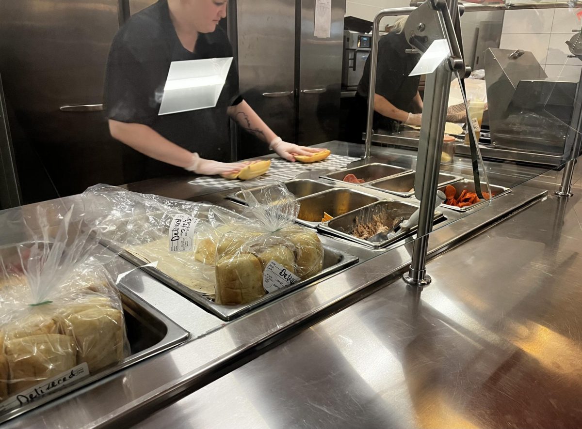 A picture of the hardworking cafeteria staff and the sub bar.
