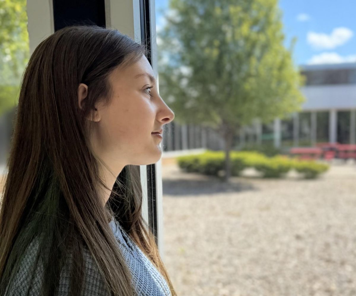 Isabelle (Izzy) Banks looks out of a window, feeling nostalgic.
